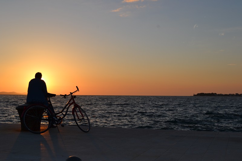 A man and his bike silhouetted against the Zadar sunset